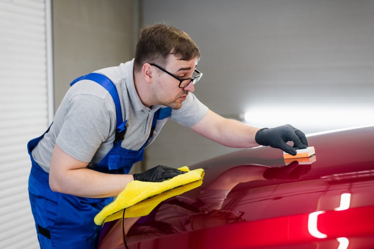 man-worker-of-car-detailing-studio-applying-ceramic-coating-on-car-paint-with-sponge-applicator.jpg